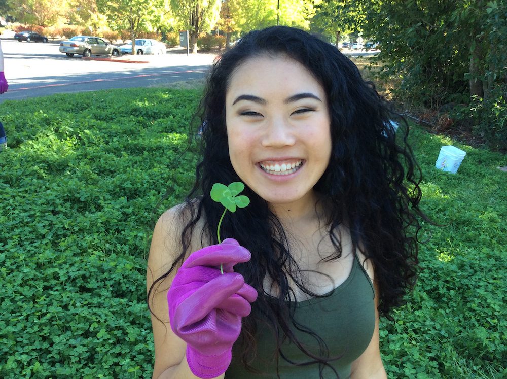Student holding four leaf clover