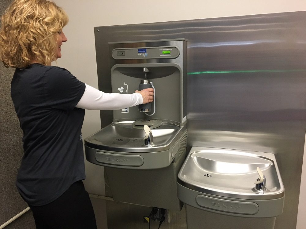 Person using water bottle filling station