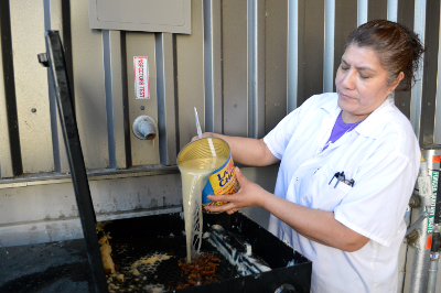 Woman pours fryer oil.