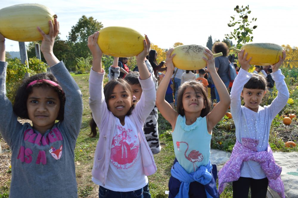 Springville Elementary first grade girls proudly holding squash over their heads. 