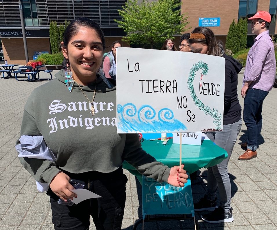student holding "La Tierra" sign