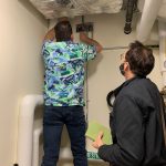 Larry Osborn, FMS Manager, and Dusty Farrell, Energy Trust of Oregon staff, check a domestic hot water relay in the SE Learning Commons Library