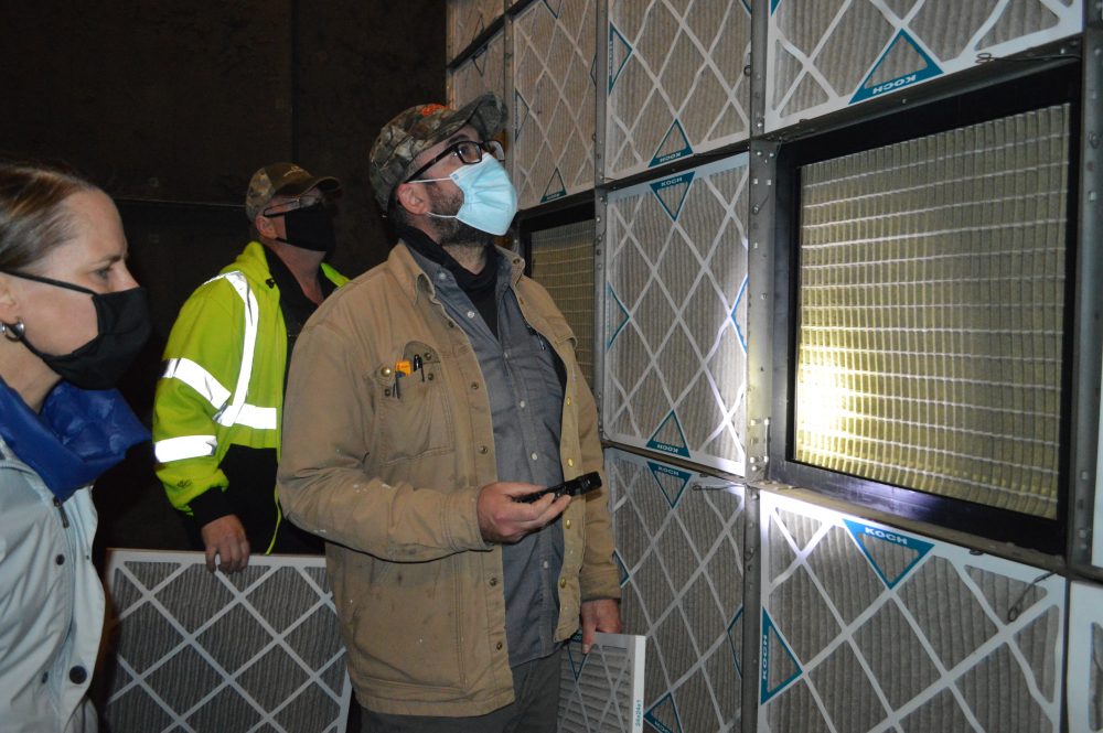 Facilities staff removing the prefilter-MERV 8 to assess the MERV 14 filter for building health and safety