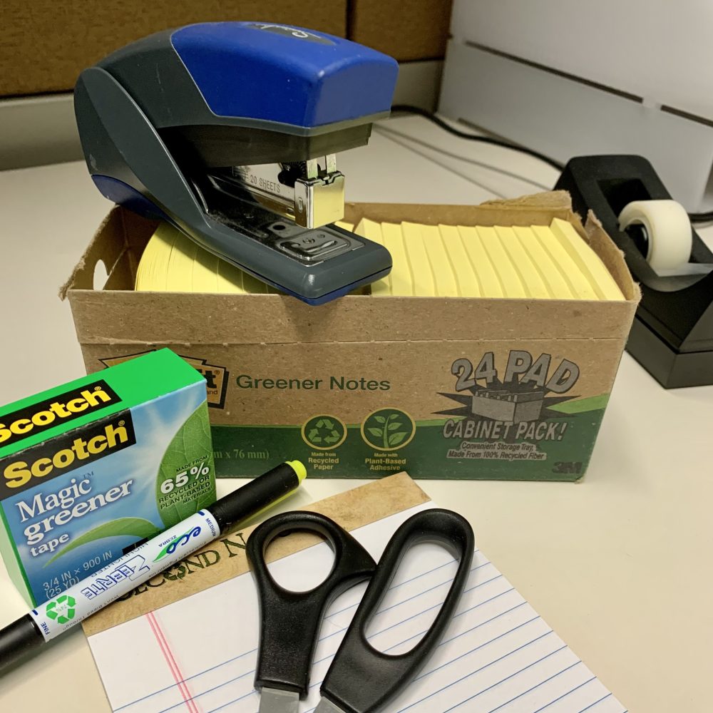 A photograph of greener office products, e.g. tape and sticky notes with recycled content