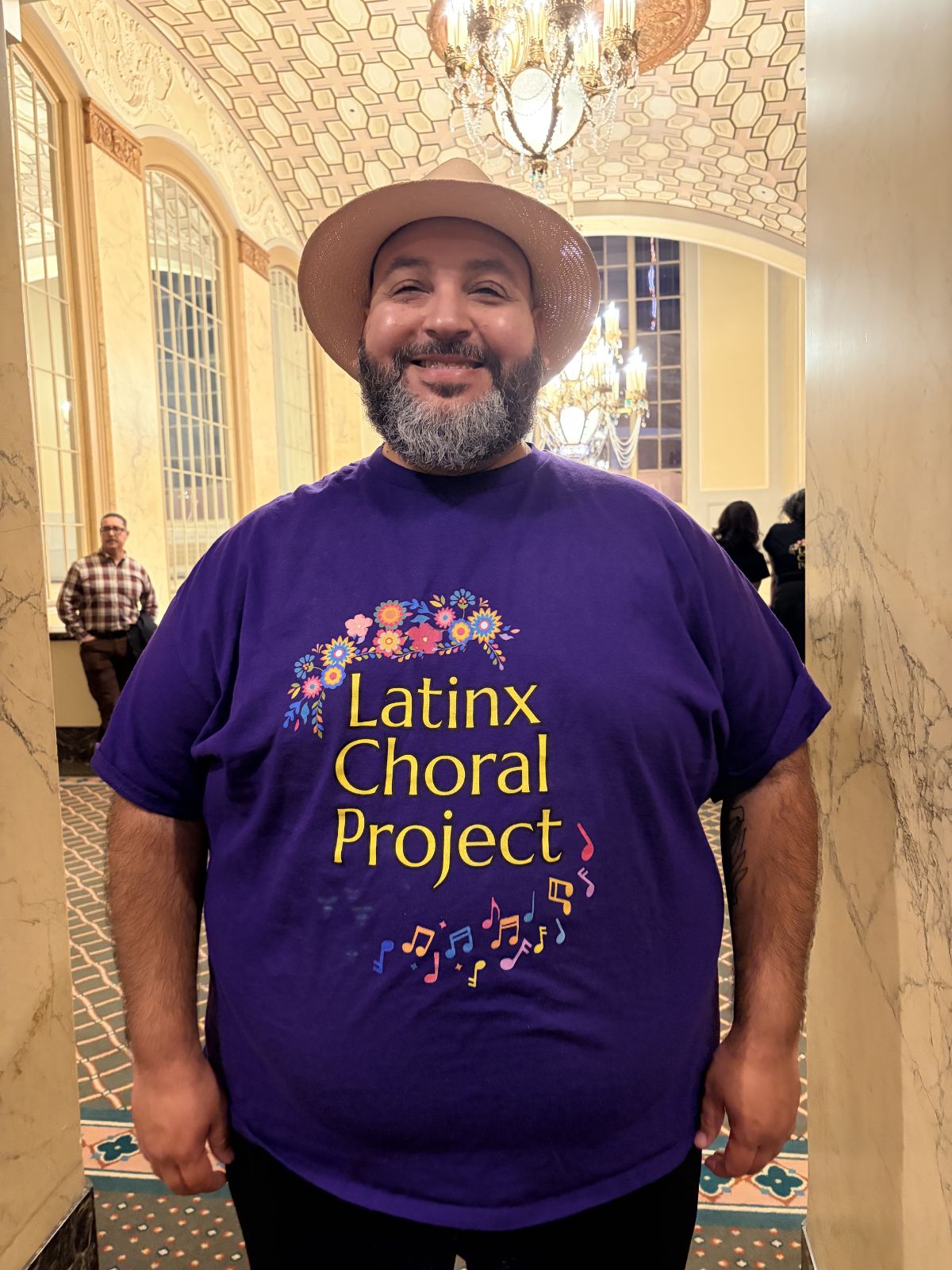 Portrait of Hobab Olivas in purple Latinx Choral Project tshirt