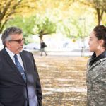 Campus president chats with student in camo coat