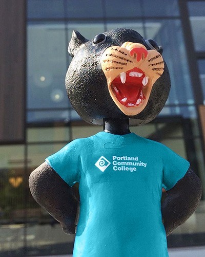 Poppie bobblehead figurine wearing a PCC t-shirt