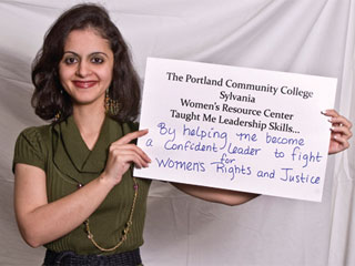 Scholarship recipient holding a sign that says 'by helping me become a confident leader to fight for women's rights and justice'