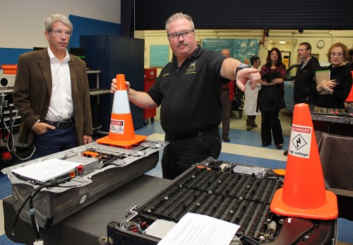 Russ Jones (right), Automotive Service Technology Program instructor, shows Congressman Kurt Schrader the Ford (right foreground) and the Honda Civic battery packs.