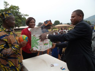 Isaac Sunday hands over his donation to school officials in Awing, Cameroon last fall.