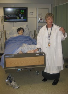 Janis Rink demonstrates how a nursing student interacts with the mannequins during a simulation.