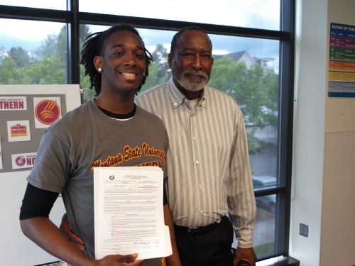 Warren Edmondson, left, joined by his father, shows off his letter of intent to play basketball for Montana State University -- Northern.