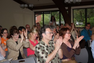 The crowd applauds the board's vote.
