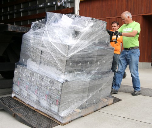 Central Distribution Services personnel Drew Smith (green shirt) and Dennis Gonzalez unload the computers at Vernonia's new K-12 school.