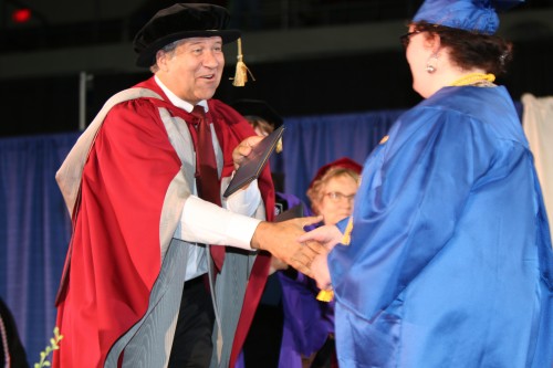 PCC President Jeremy Brown hands out diplomas on stage at the Memorial Coliseum during the college’s commencement in June.