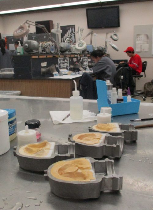 Molding dentures, foreground, is part of the curriculum of PCC's Dental Laboratory Technology program, which has been at PCC since 1967. The majority of local dental labs are owned by graduates of the program.
