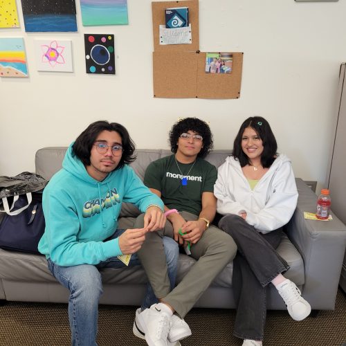 Three students sitting on couch smiling